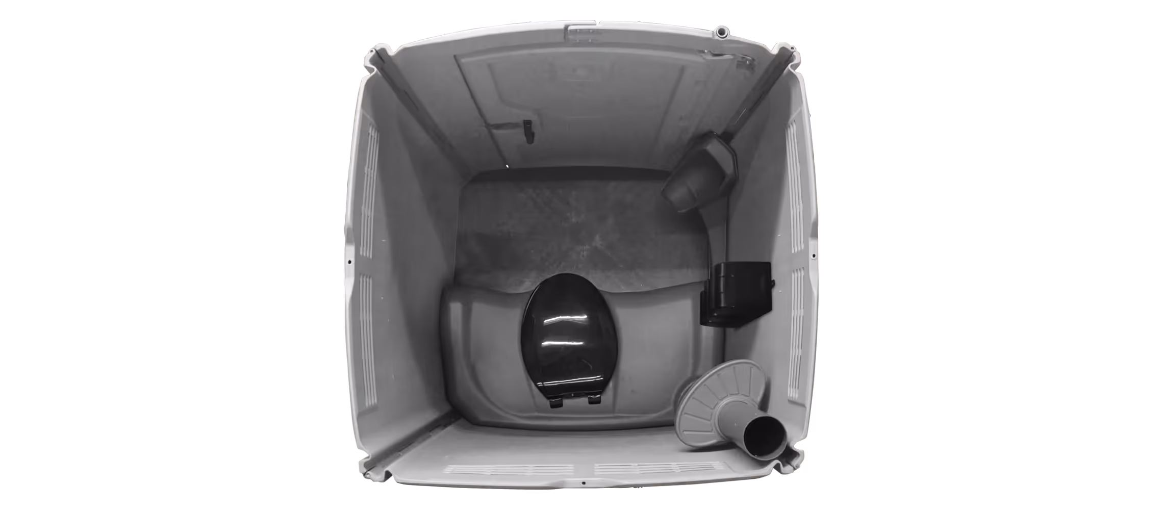 Interior view of a portable toilet showing a toilet seat, flush tank, and waste pipe.