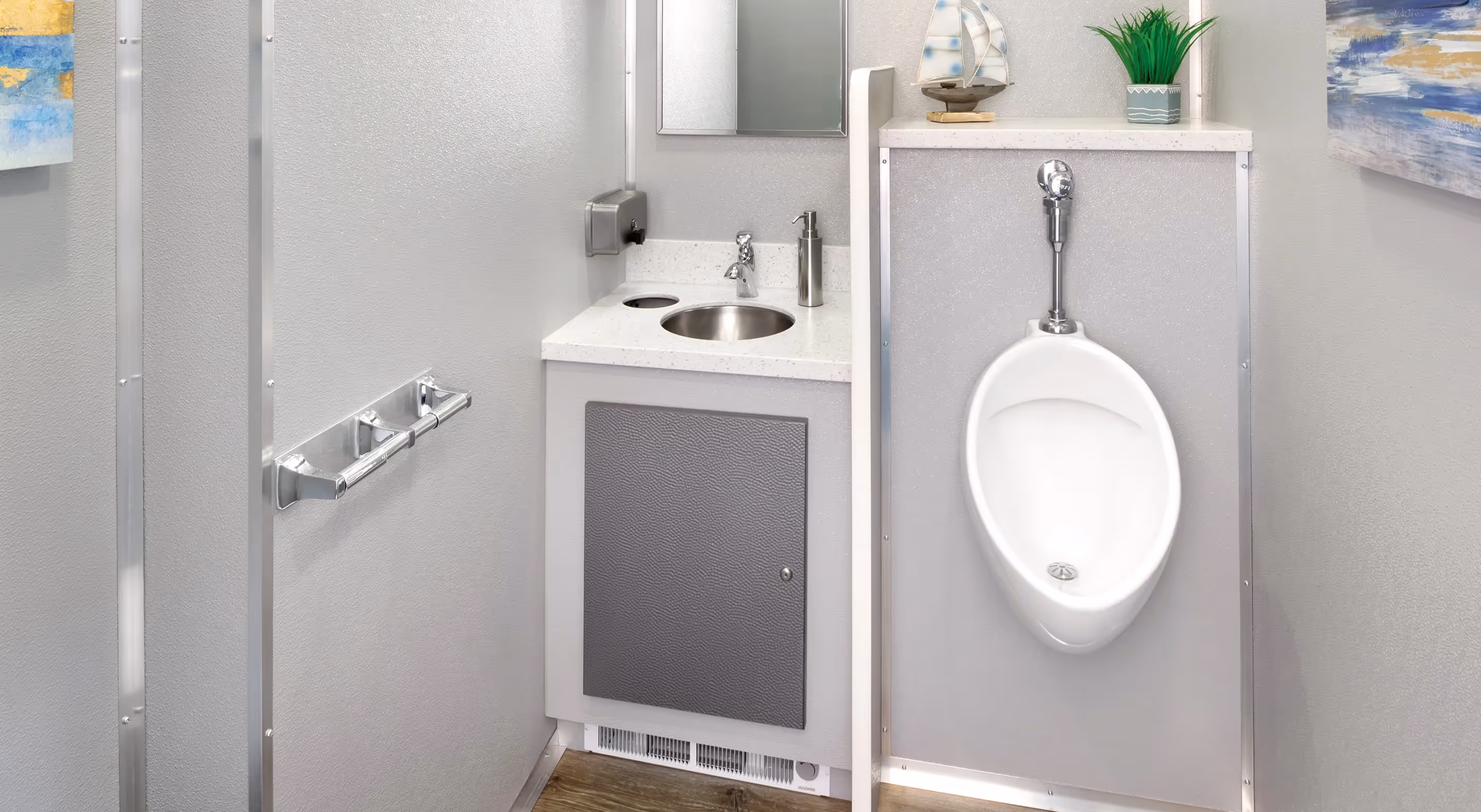 Modern men's restroom with stainless steel sink, urinal, soap dispenser, and decorative plant and sailboat.