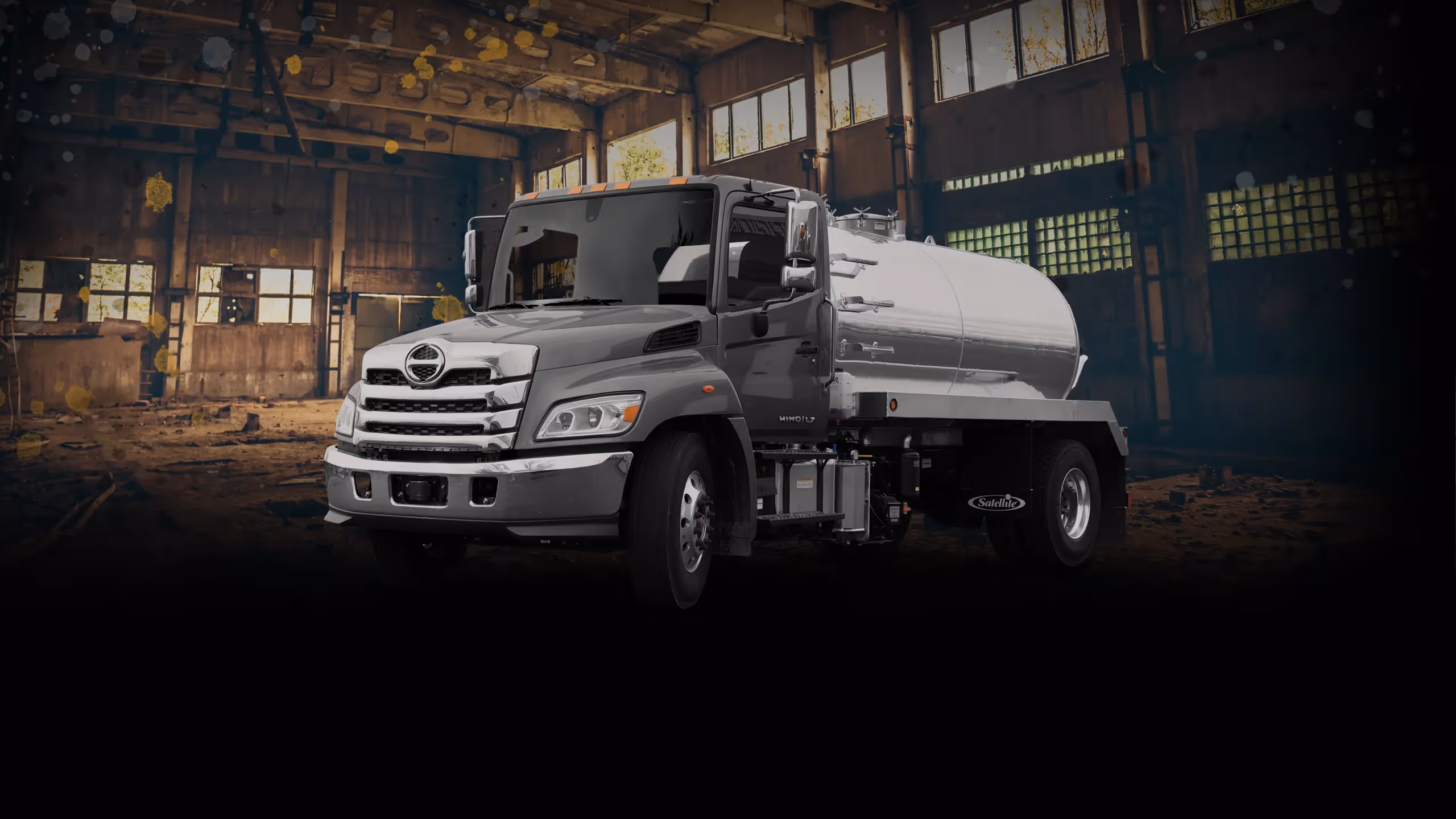 Gray MAL 2500 truck with a fuel tank, set in an industrial backdrop.