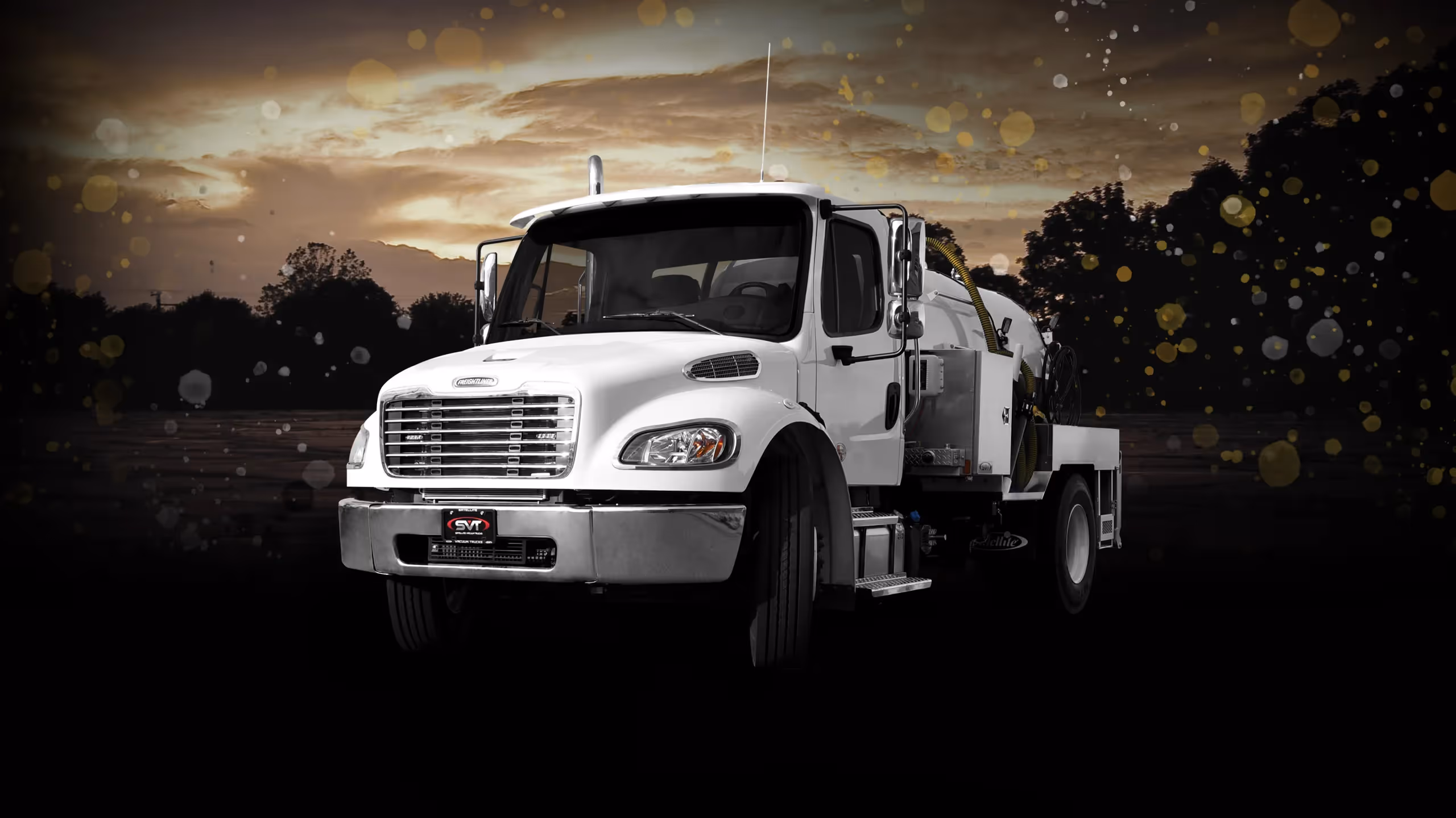 White MD 1600 truck with a silver tank, set against a dark, blurred landscape.