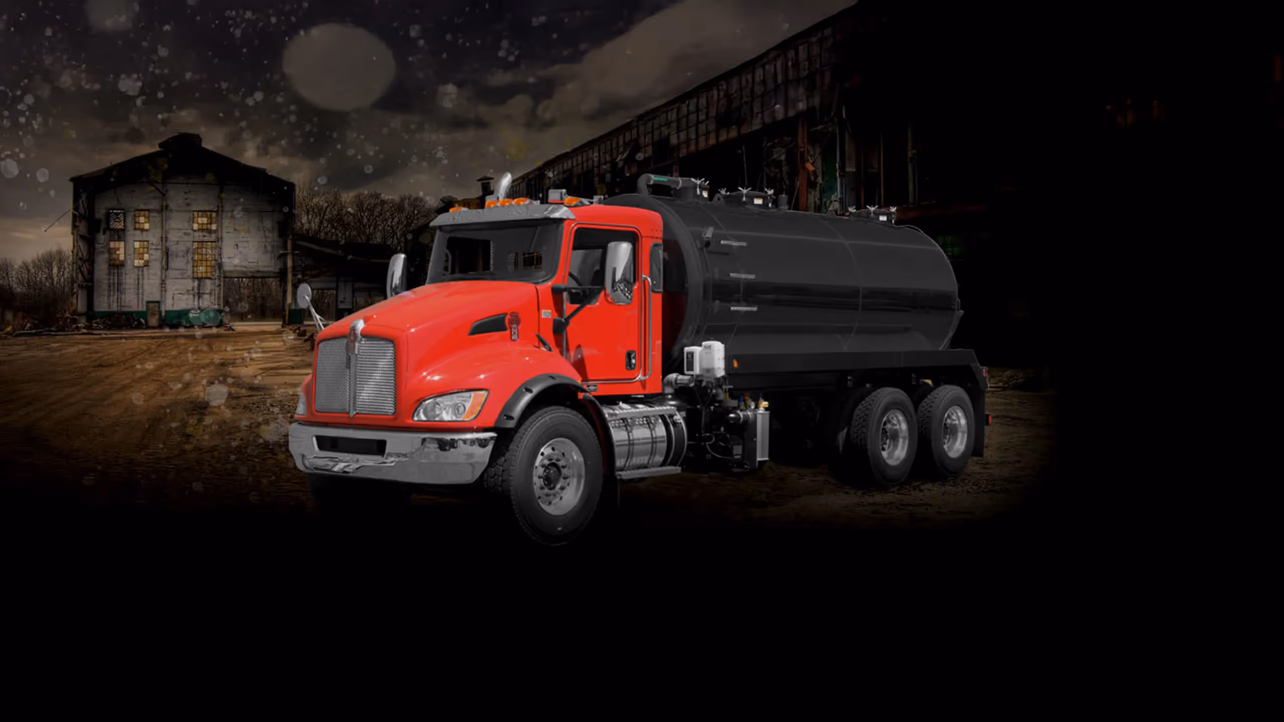 Red MD 3400 truck parked near a dilapidated building in a dark, snowy environment.