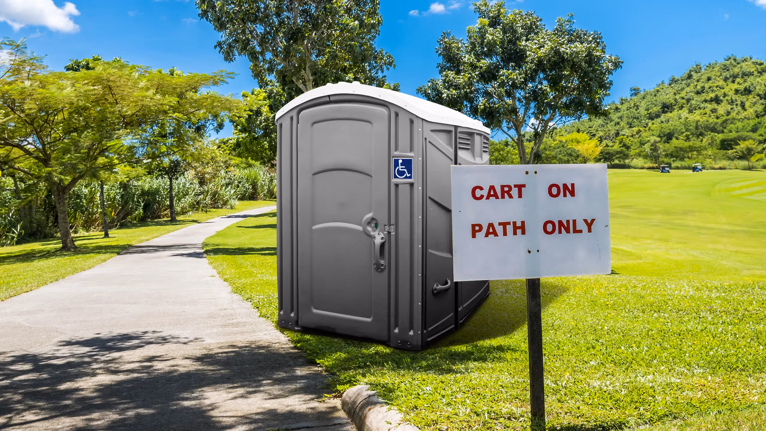 Portable toilet on a green path, with a sign reading "CART ON PATH ONLY" nearby.