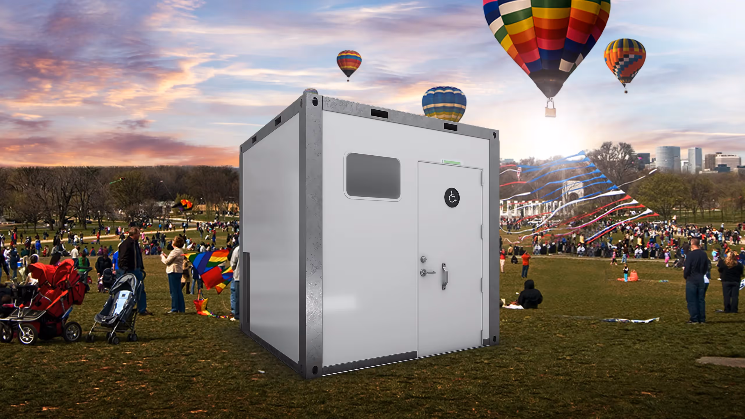 Sanitrax ADA Module in a park filled with people and hot air balloons overhead.