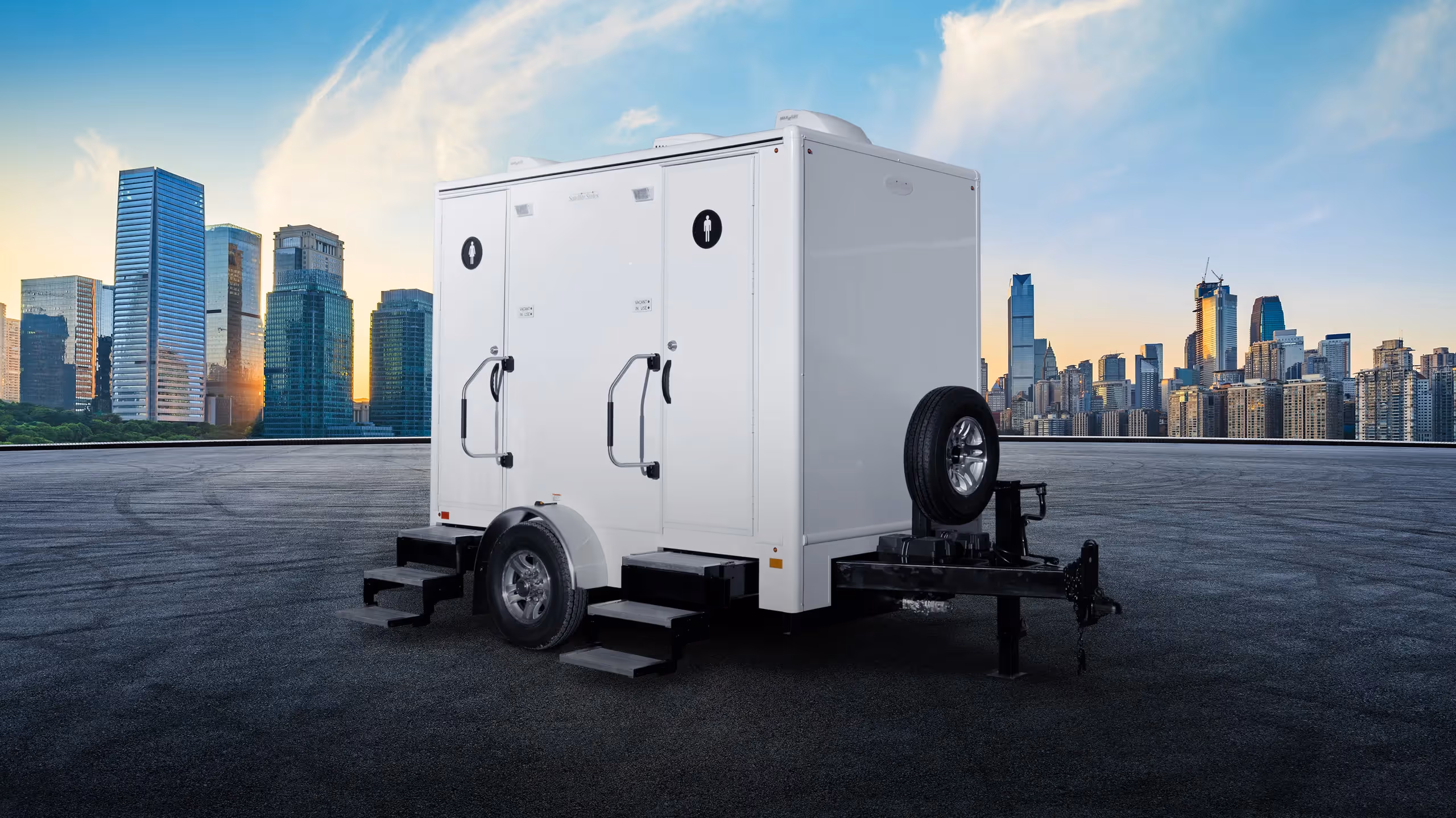 White 6x10' 2-door, 2-station trailer in front of a city skyline on a clear day.