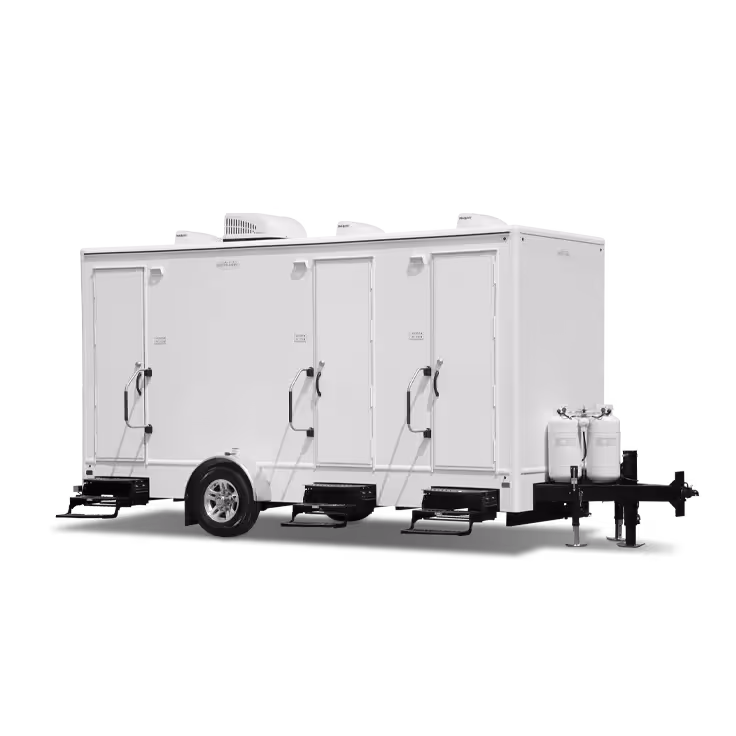 A white, three-station shower combo trailer with multiple access doors and portable water tanks.