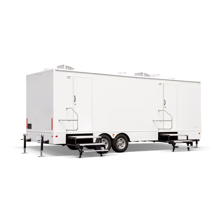 White restroom trailer with two entrances and four air conditioning units on the roof.