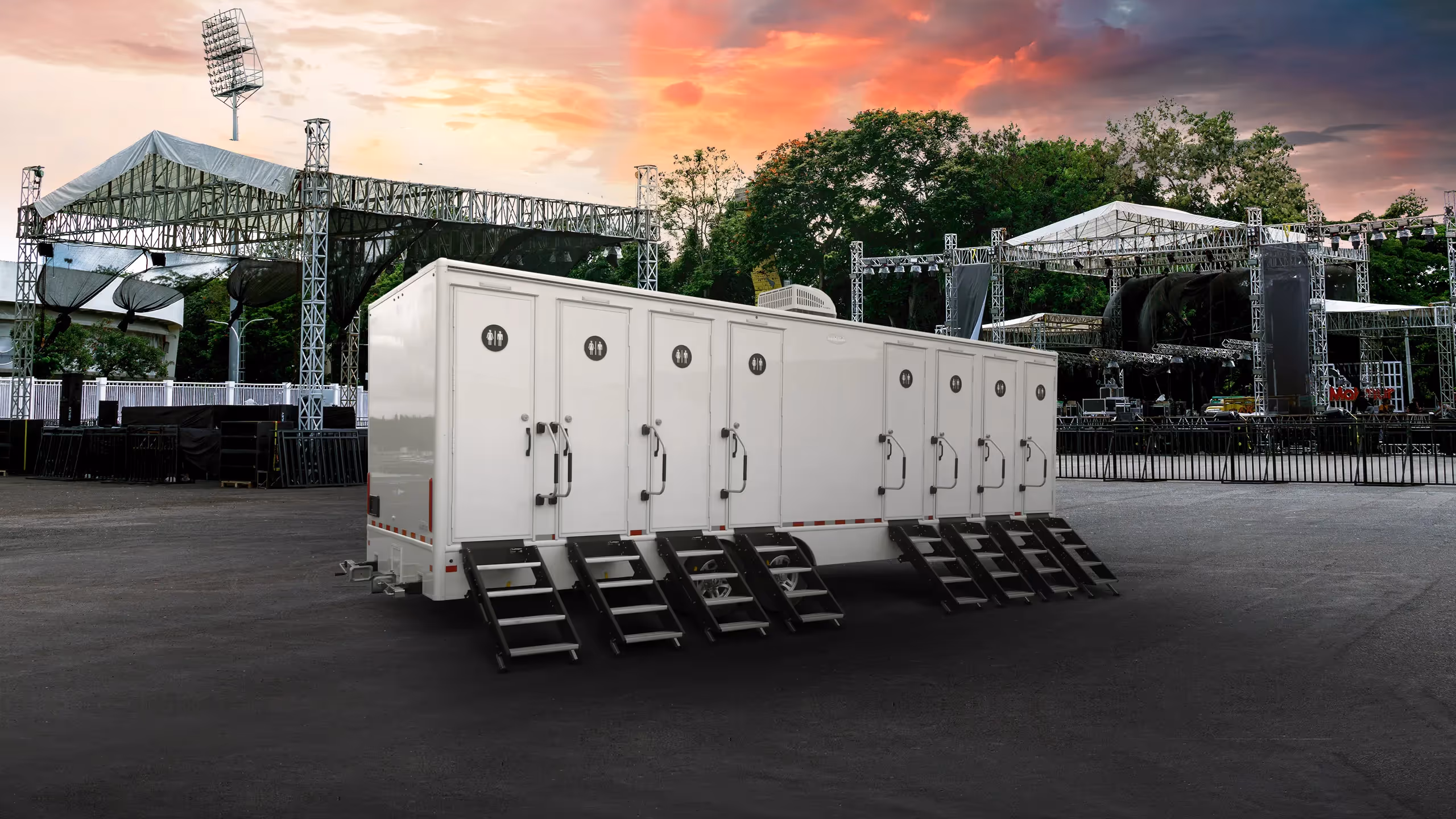 Mobile restroom trailer with 8 doors and 8 stations, set against a concert venue backdrop.