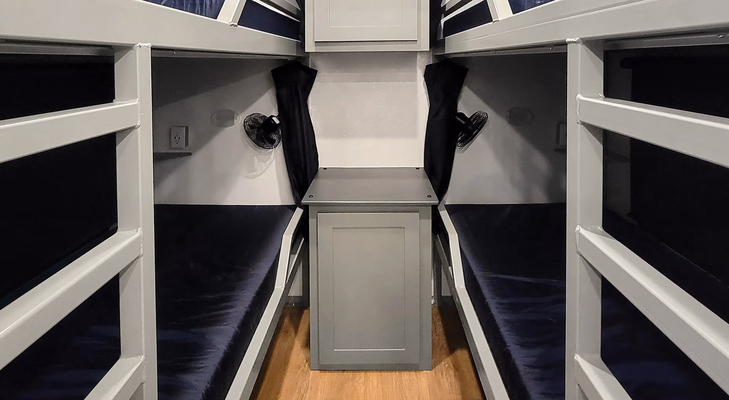 Interior view of a command center featuring bunk beds and a central table between them.