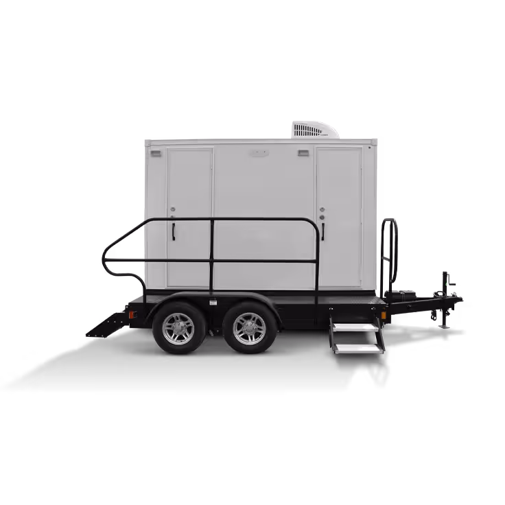 Portable restroom trailer with two entrances and a towable hitch on a black background.