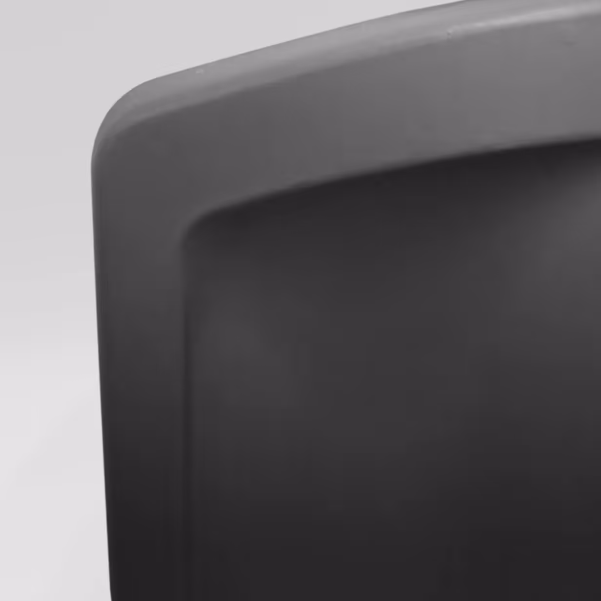 Close-up of a black plastic container's corner with rounded edges and smooth surface.