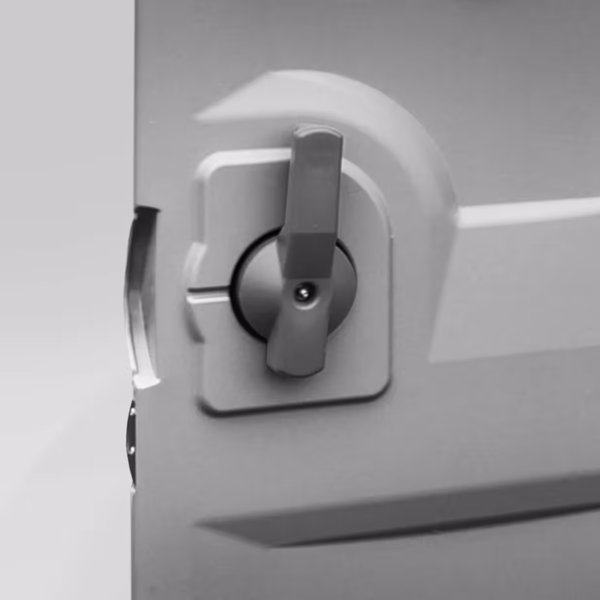 Close-up of a gray plastic handle latch on a molded door or panel.