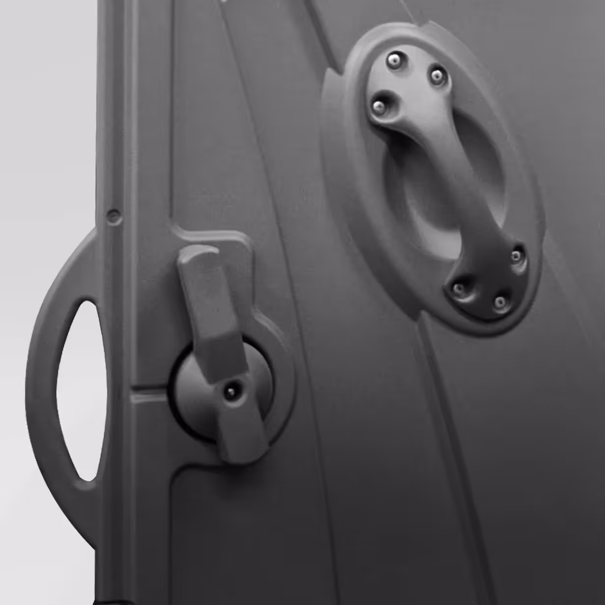 Close-up of a black plastic latch handle and grip on a container or door.