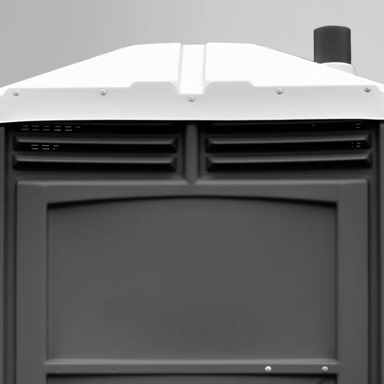 Close-up of a white portable toilet roof with molded ventilation vents and a black exhaust pipe.