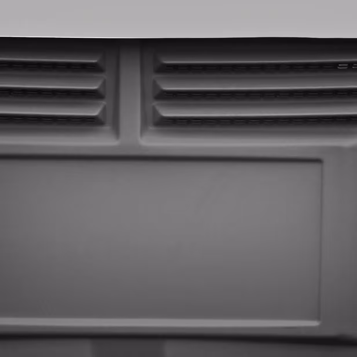 Close-up of a gray molded panel with two rows of vent slots at the top.