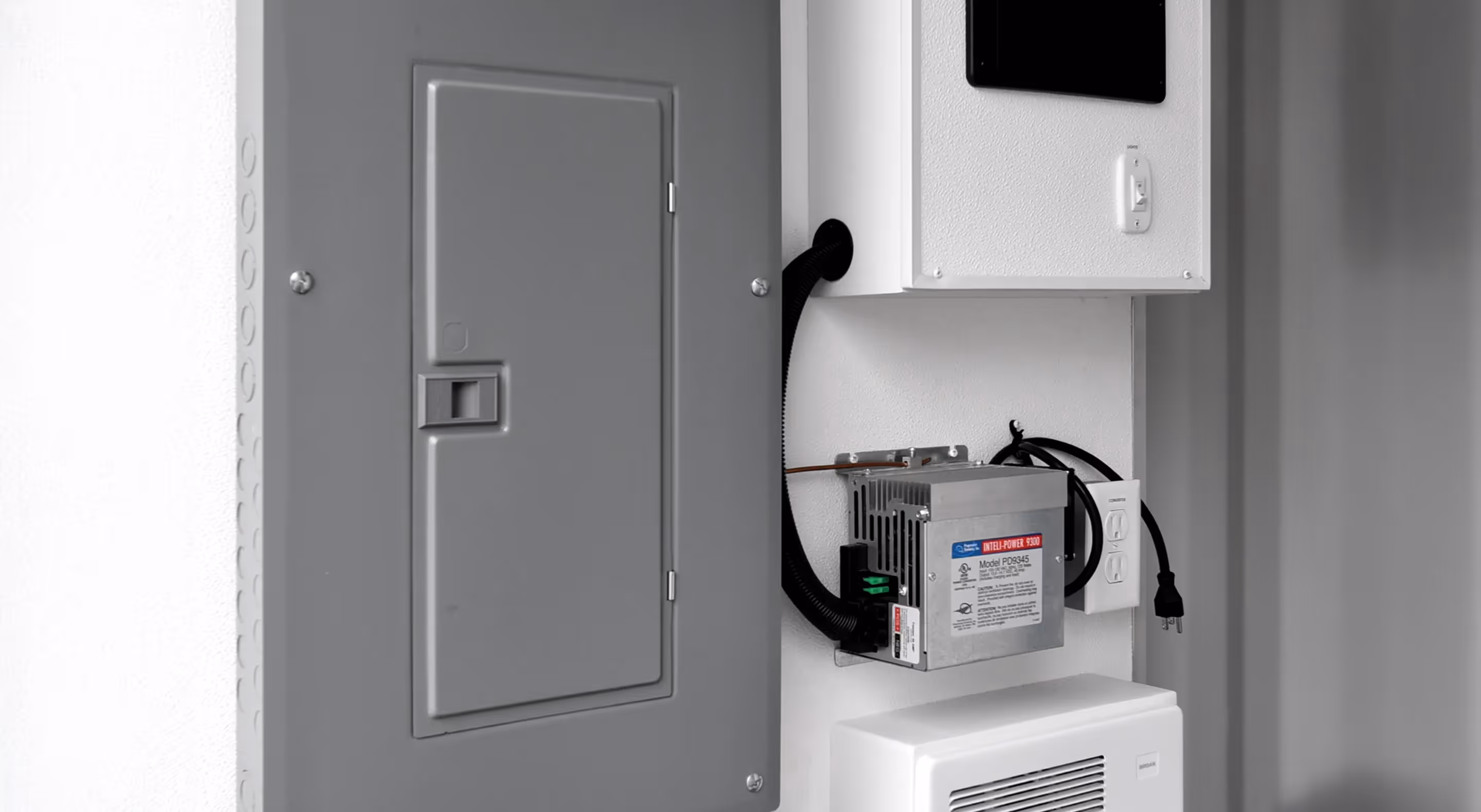 Electric panel and connected equipment mounted on a wall, featuring a display and wiring.