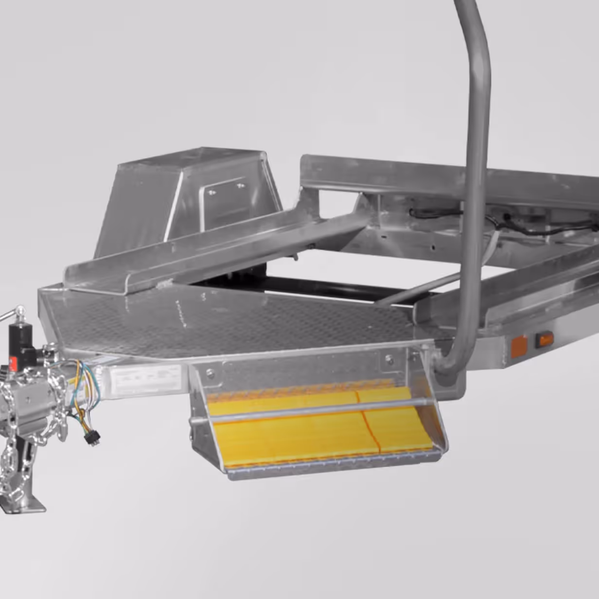 Close-up of a metal trailer frame with yellow wheel chocks attached underneath.