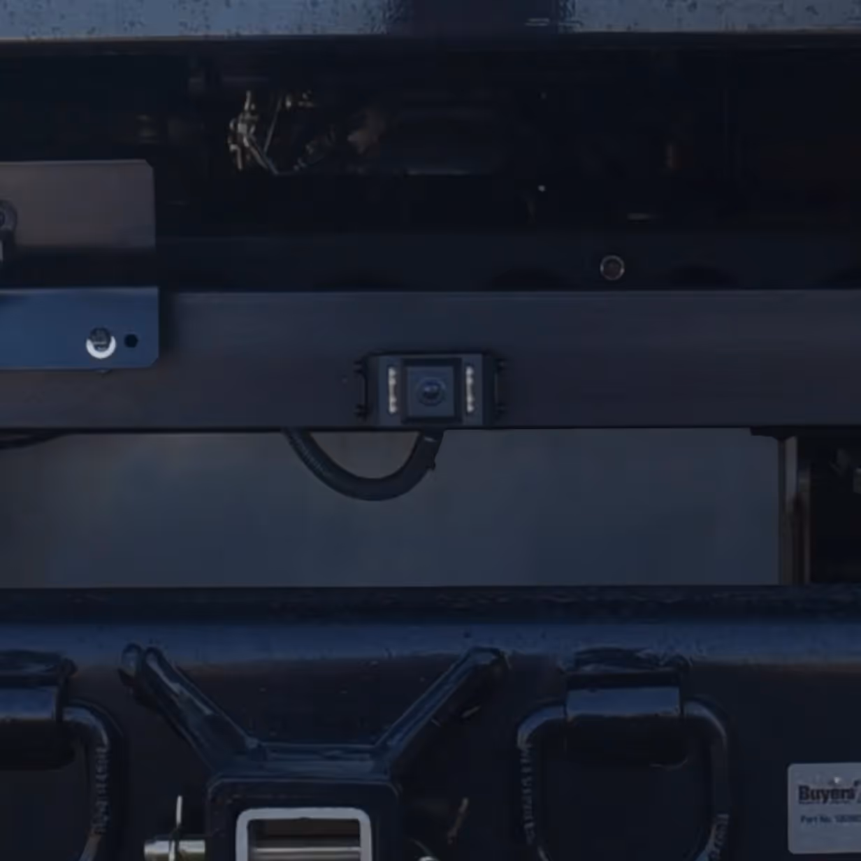 Backup camera mounted on the rear of a vehicle with a hitch receiver below it.