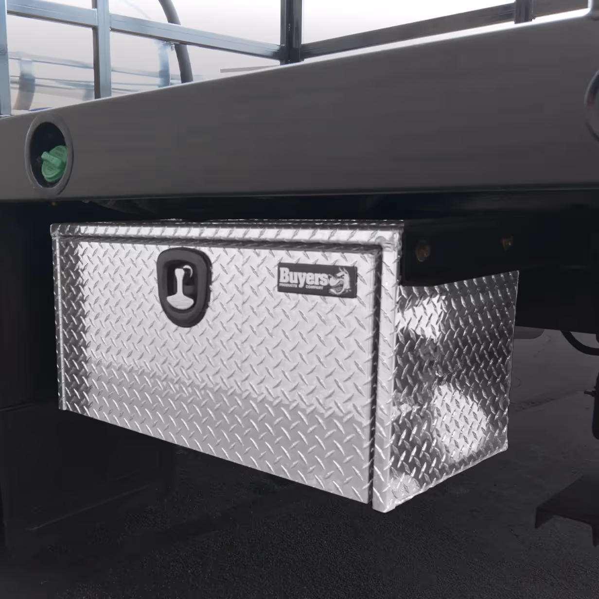 Diamond plate aluminum truck tool box mounted under a truck bed with a black latch and Buyers logo.