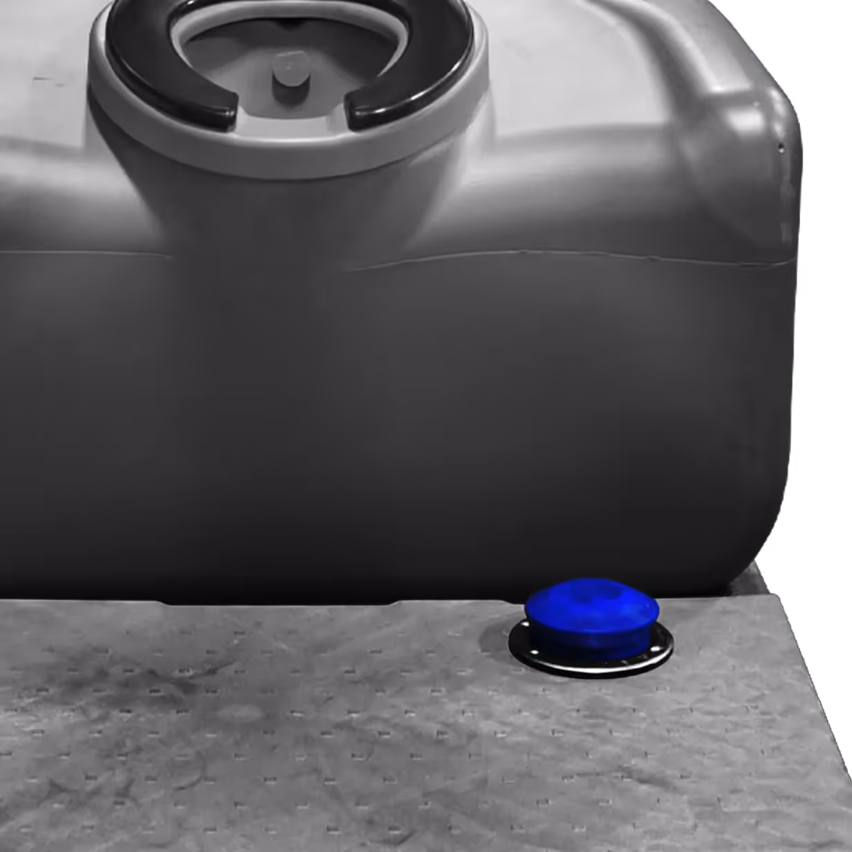 Blue button on a textured gray metal surface near a large gray plastic container with a handle.
