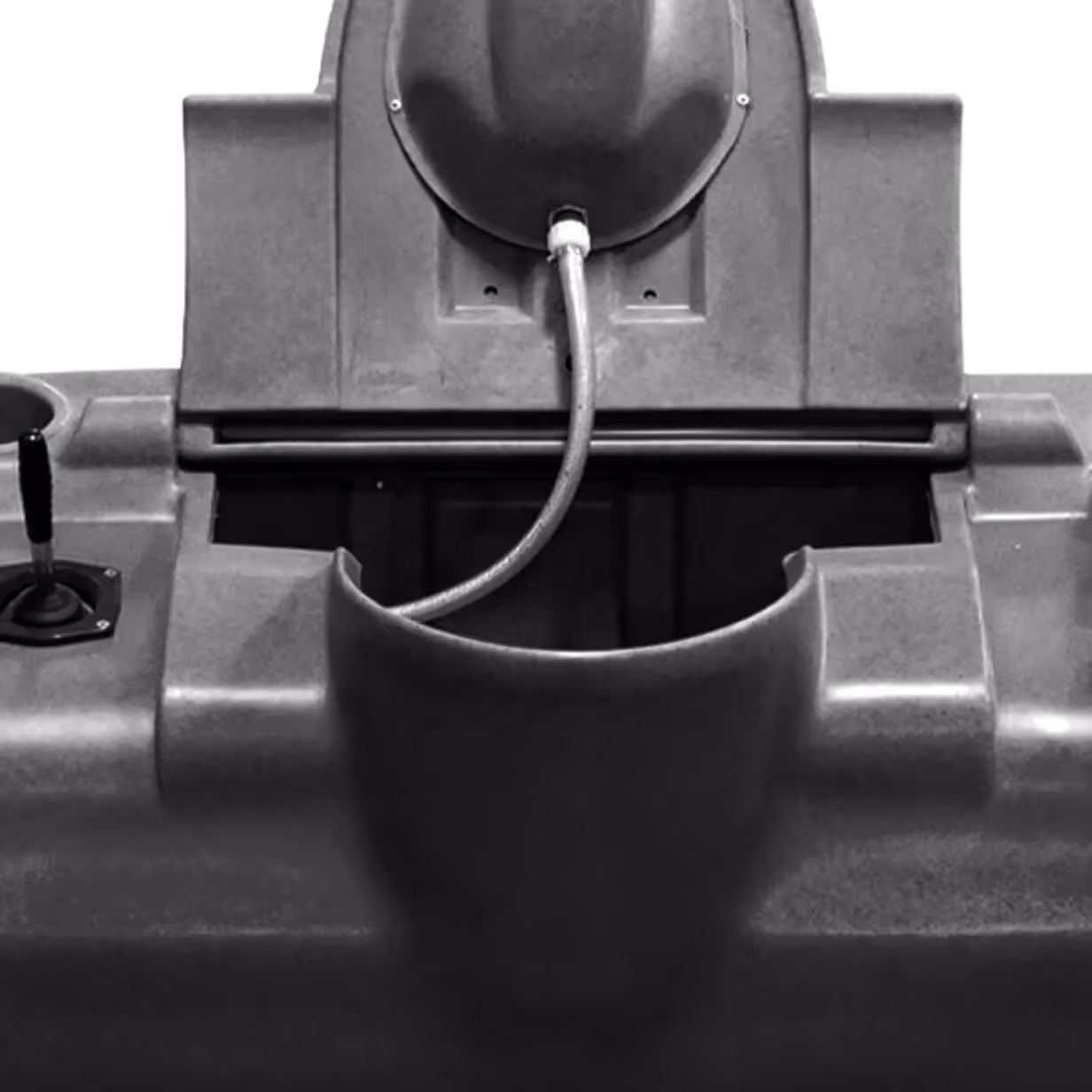 Close-up of a control panel with joystick and hose on a gray industrial machine.