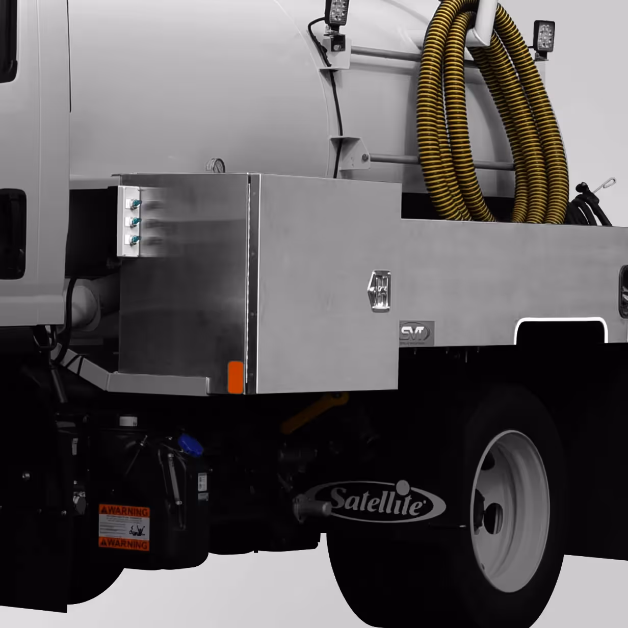 Side view of truck with stainless steel utility cabinet and yellow coiled hoses mounted on its platform.