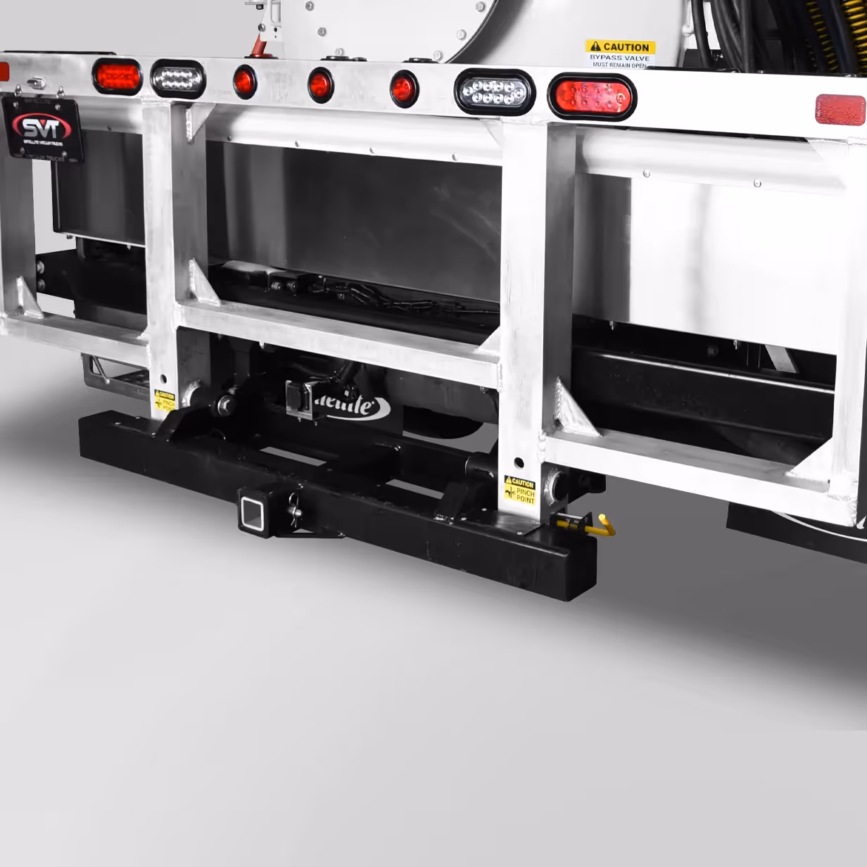 Rear section of a metallic truck bed with red and white lights and caution labels.