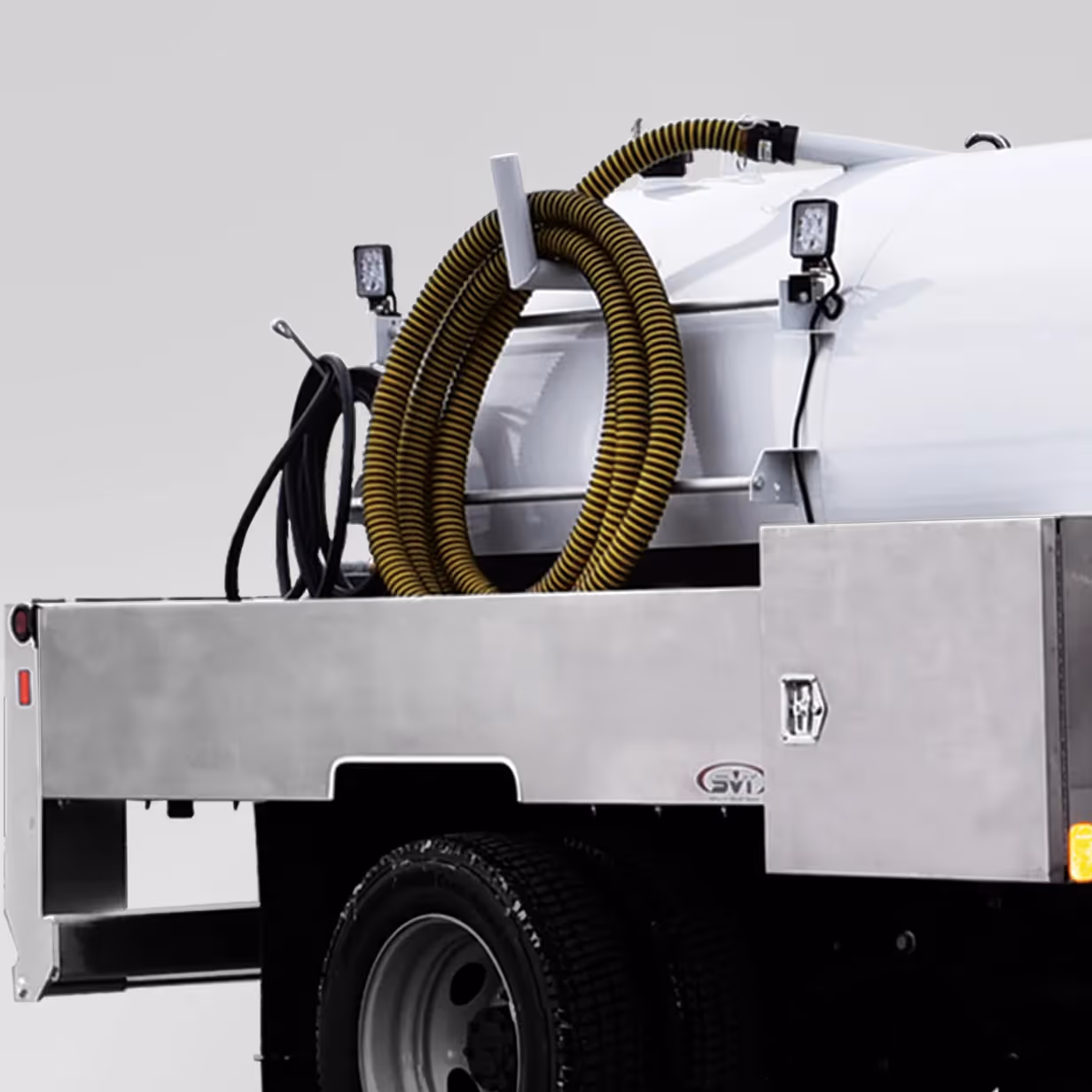 Back section of a service truck with coiled yellow hose and equipment box on the flatbed.