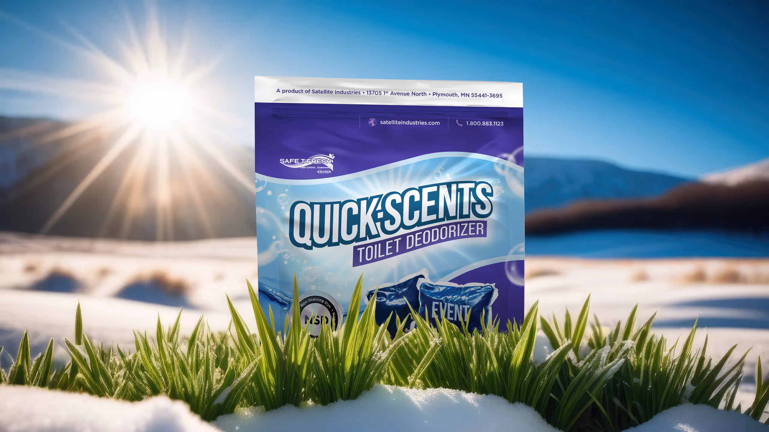 Quick Scents toilet deodorizer package standing in snow with green grass and bright sun in background.