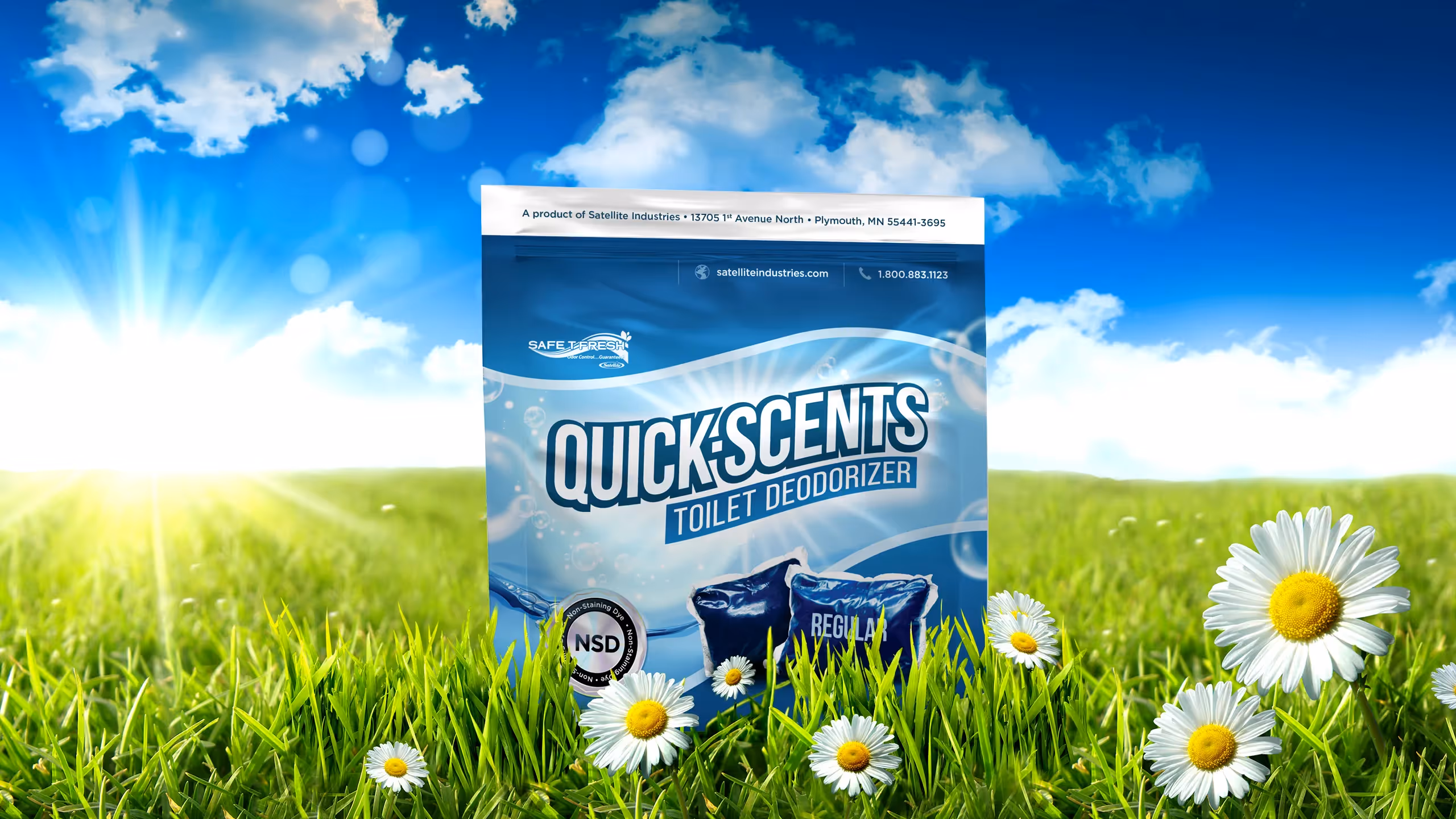 QuickScents toilet deodorizer pack in a bright, sunny meadow with flowers and blue sky.