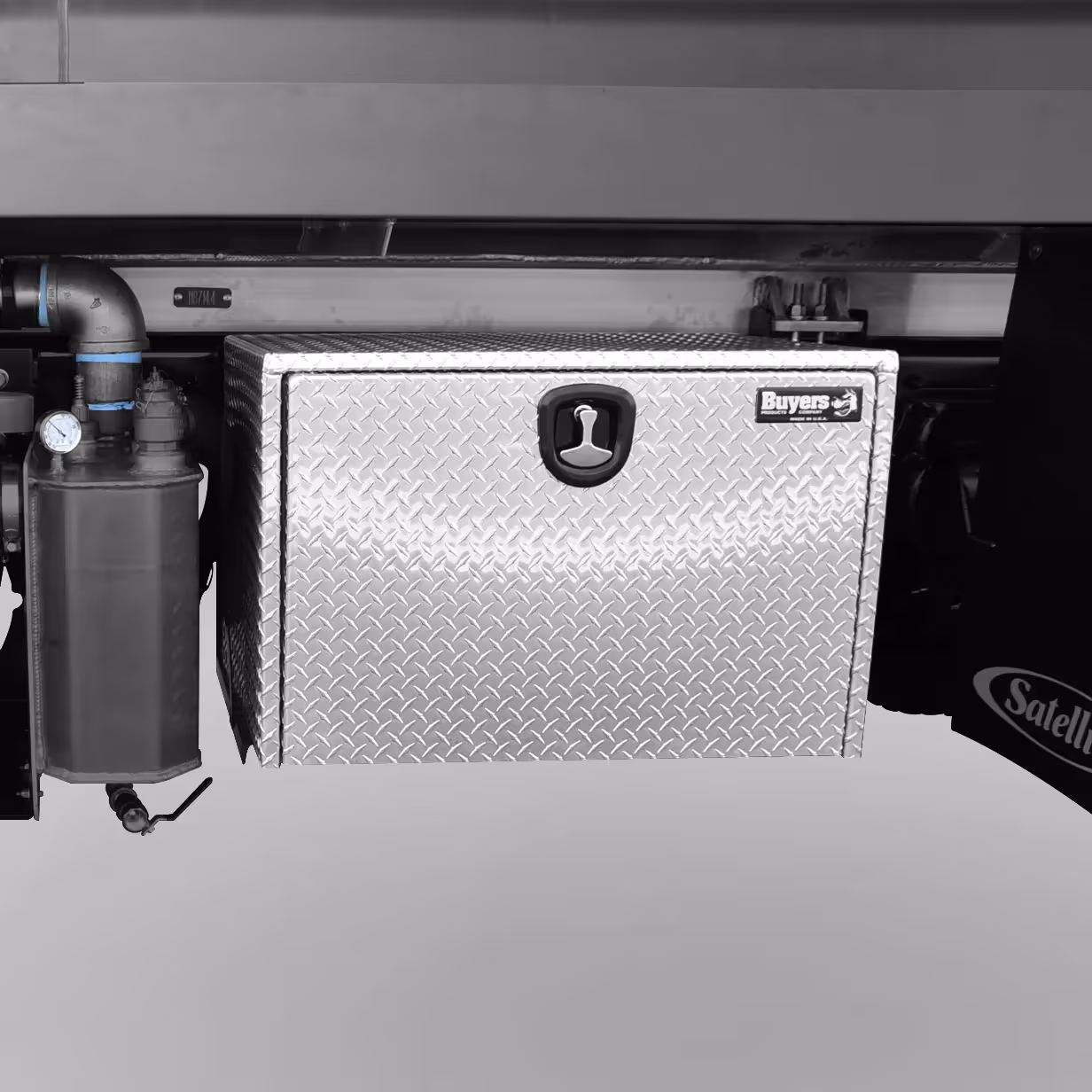 Metal diamond plate storage box with handle and Buyers Products logo mounted under a vehicle bed.