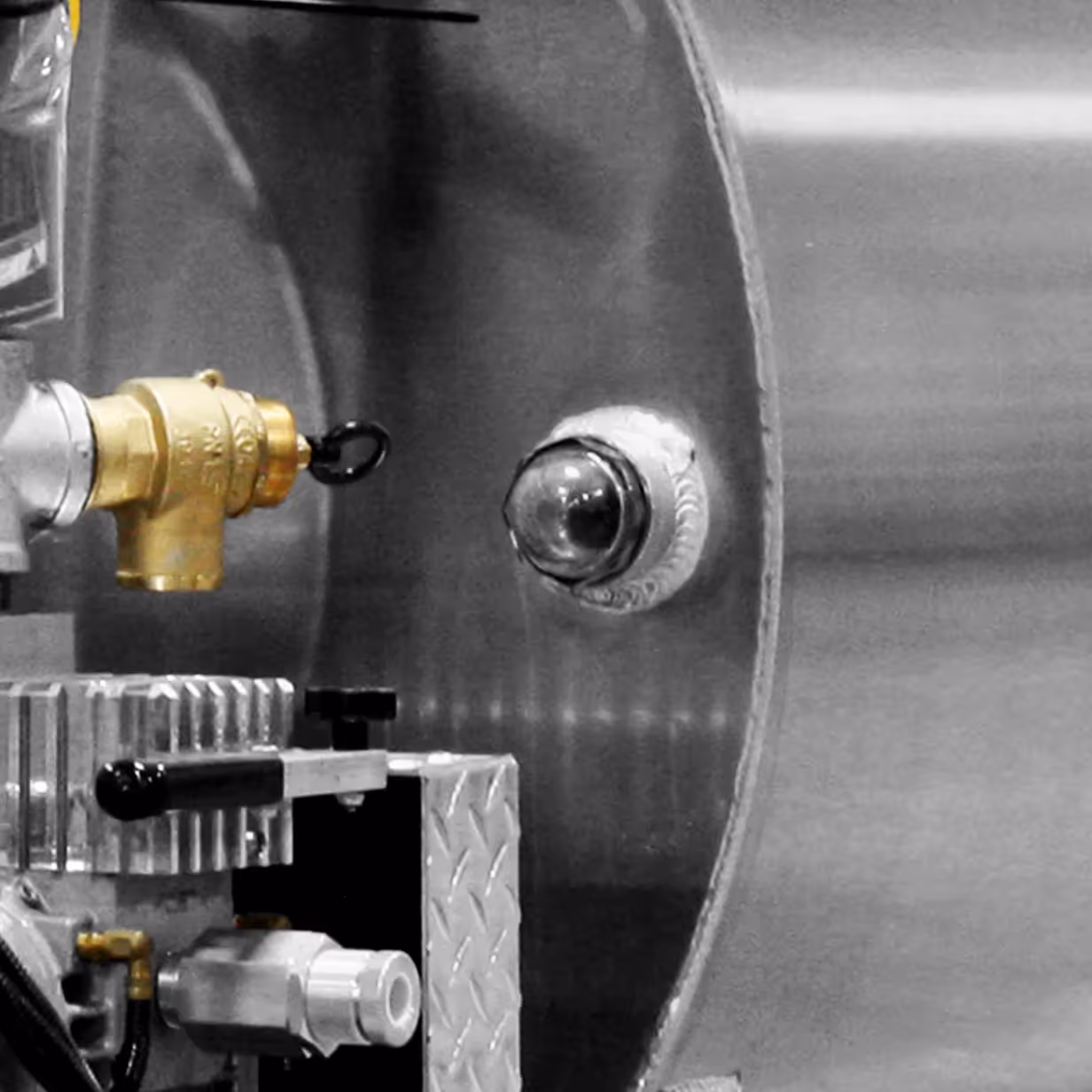 Close-up of mechanical parts including a brass valve, a glass dome, and metal components.