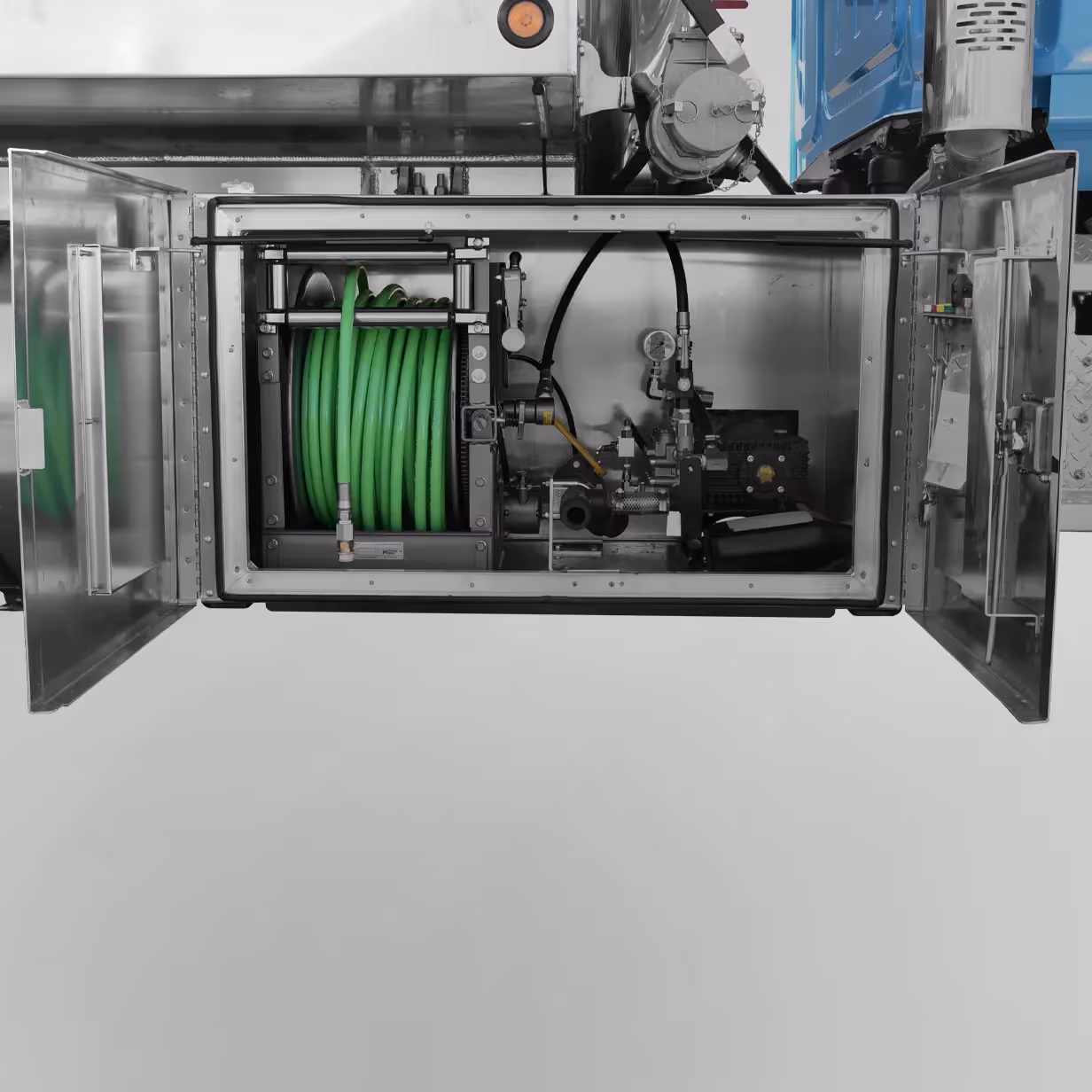 Open metal compartment on truck showing green coiled hose and pump system inside.
