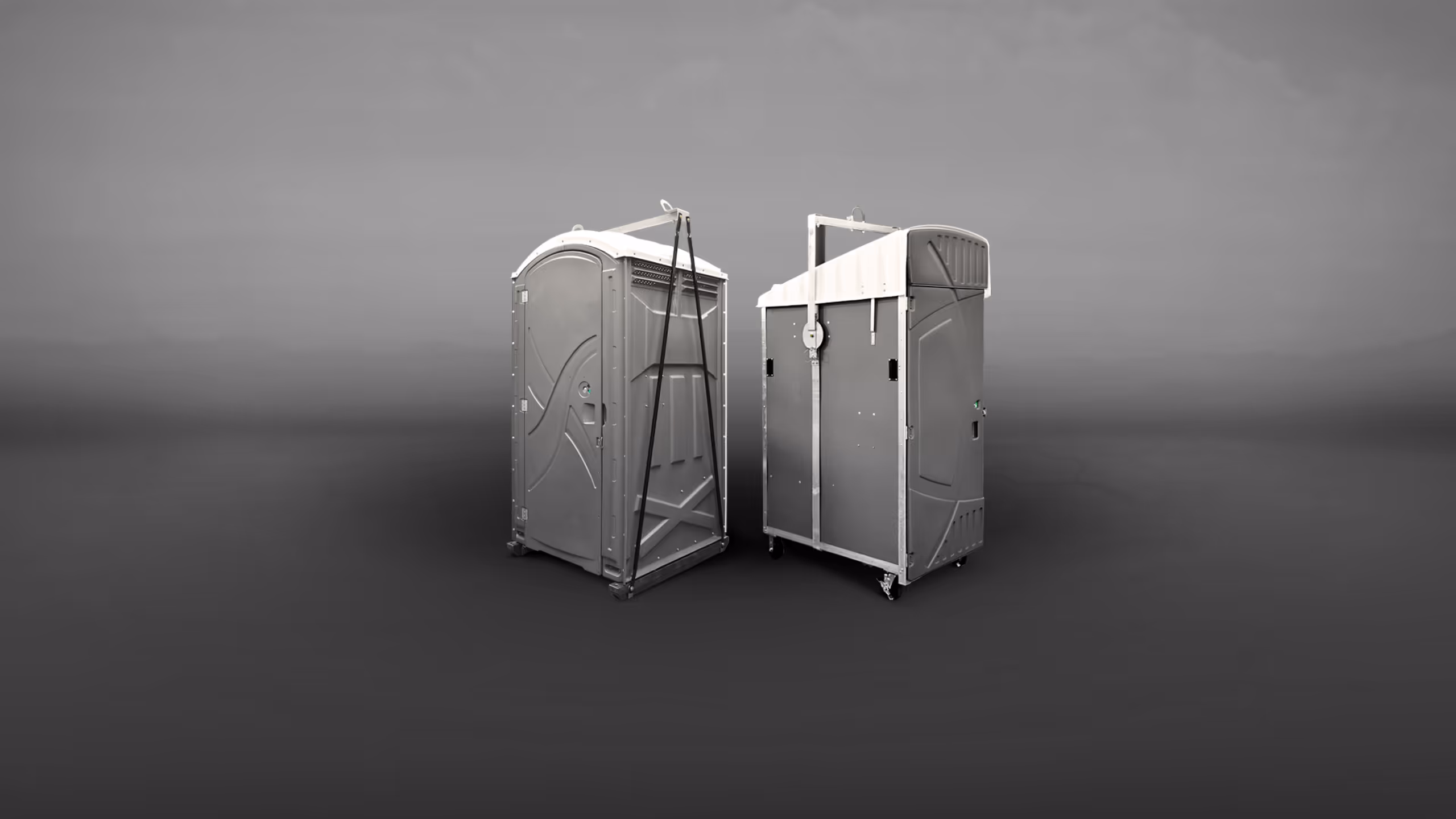 Two gray portable restrooms positioned side by side on a plain background.
