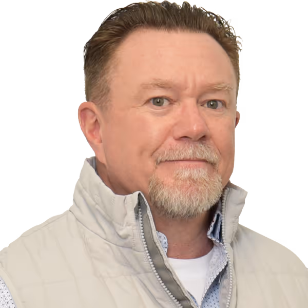 Middle-aged man with light beard wearing a light quilted vest and blue patterned shirt.
