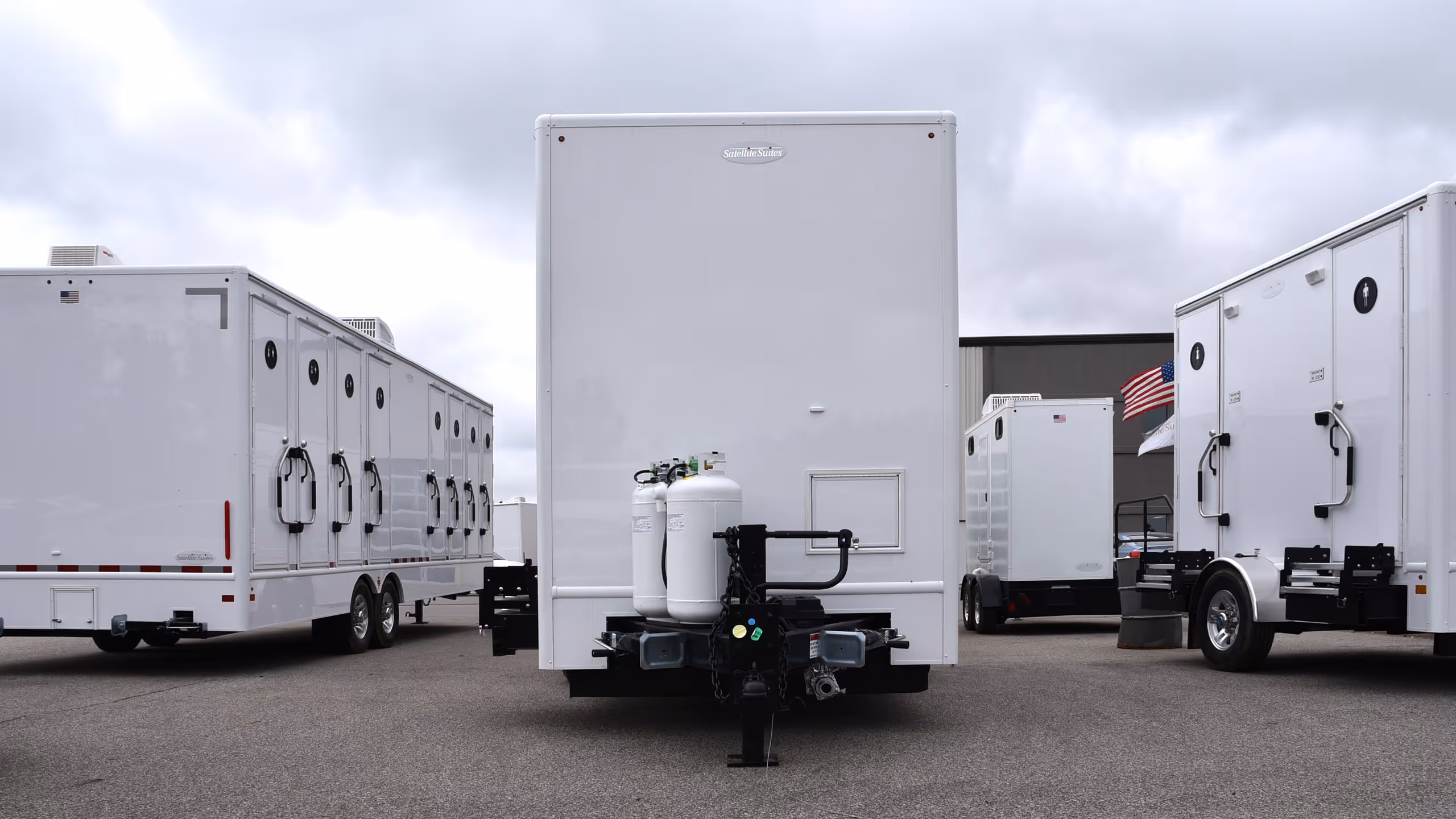Three white trailers are parked in a lot, with one prominently facing the camera.