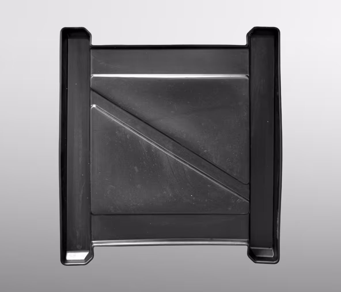 A black rectangular paint tray with sloped sections for paint mixing and a smooth base.