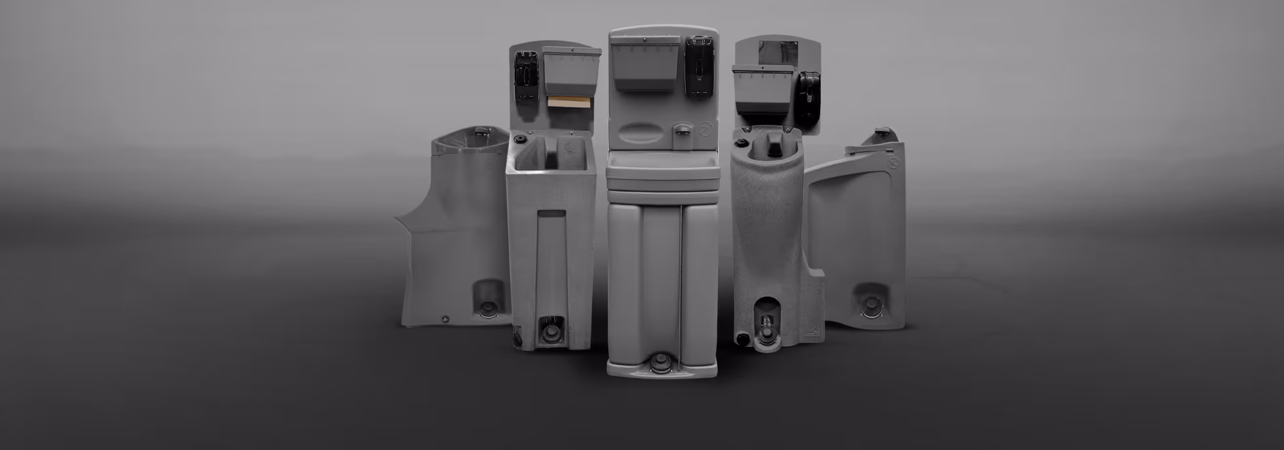 Five commercial handwashing stations arranged in a row against a gray background.