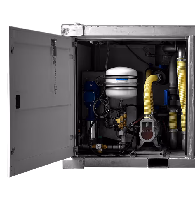 Open metal cabinet housing industrial pump system with pipes, yellow hoses, gauges, and a white pressure tank.