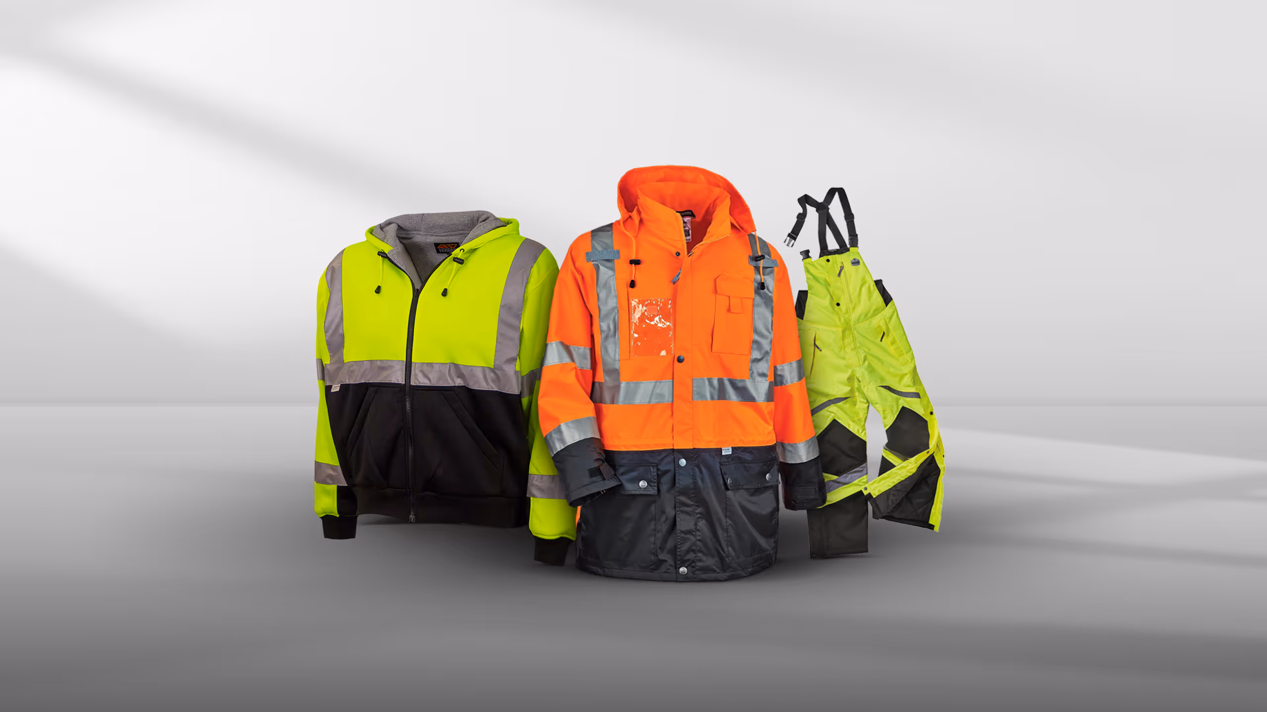 Three high-visibility jackets in various colors: yellow, orange, and a yellow/black mix.