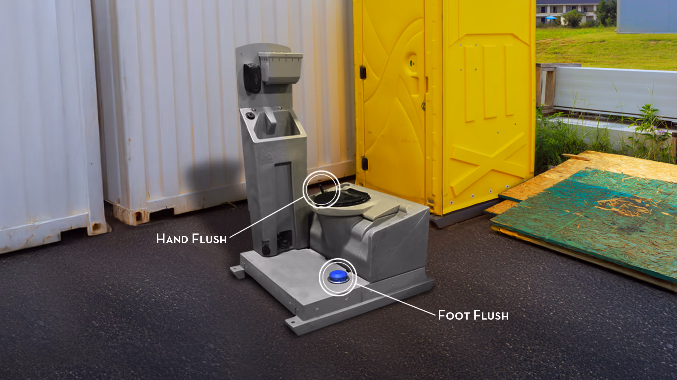 Sanitation station with hand and foot flush options next to portable restroom and shipping