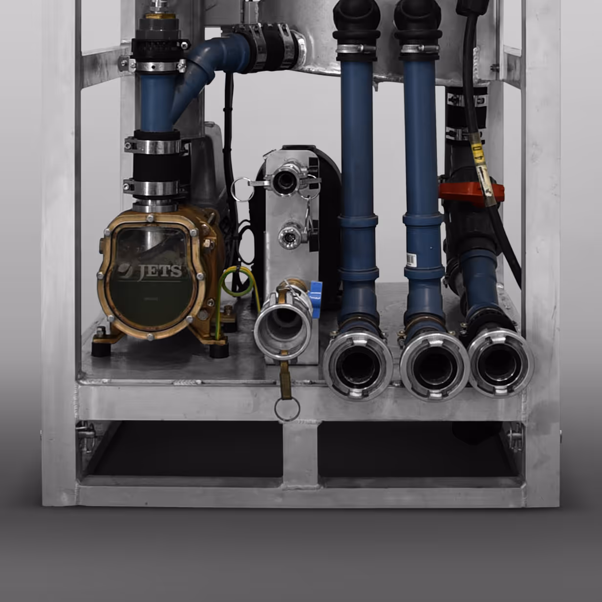 Close-up of industrial piping and equipment with blue pipes and a pump labeled 'JETS' mounted in a metal frame.