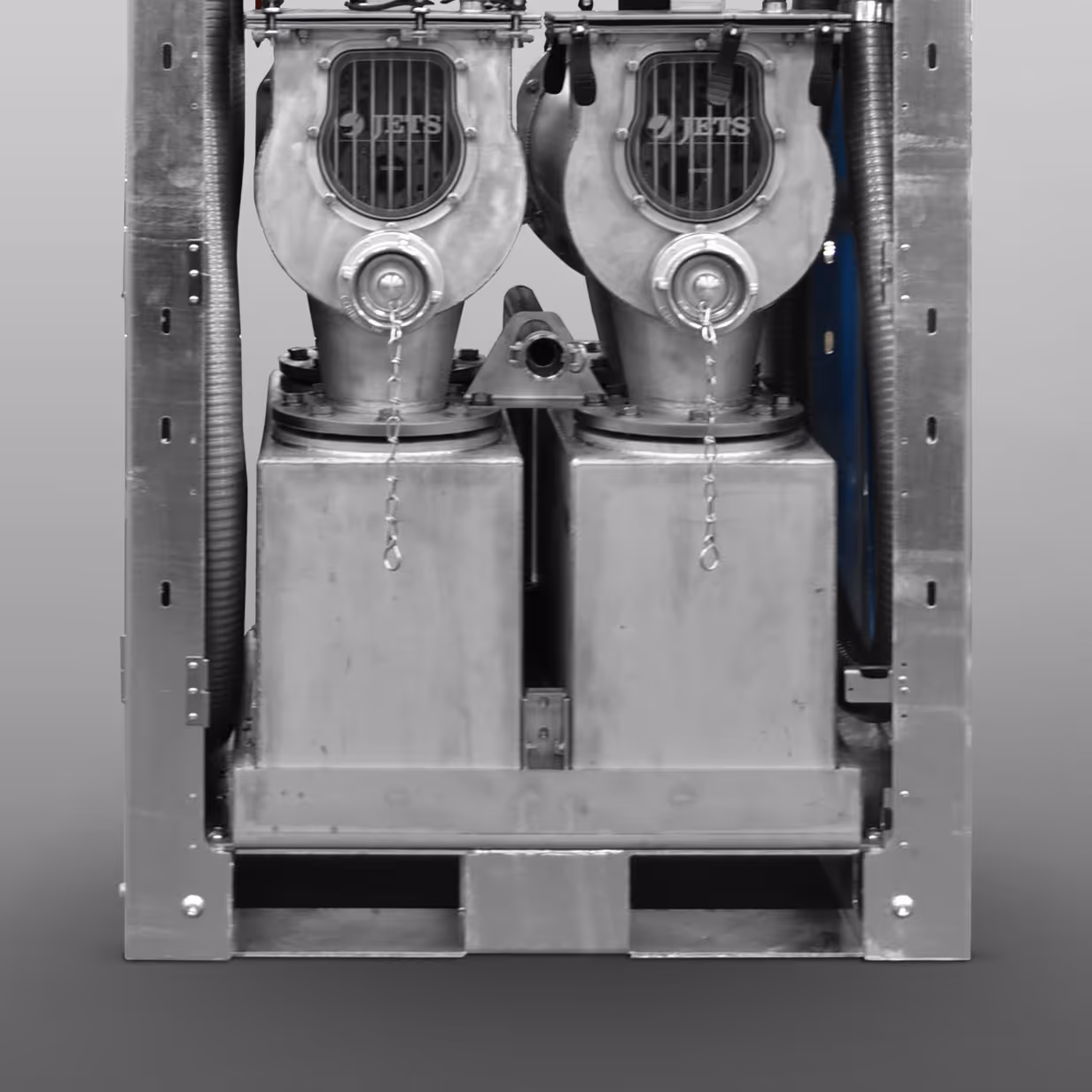 Close-up of industrial modular equipment with two metal blower units labeled JETS inside a metal frame.