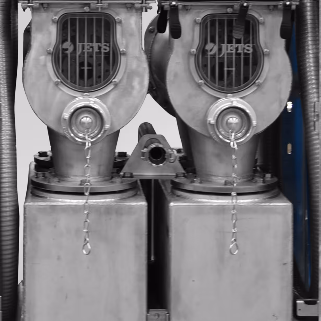 Close-up of two metallic JETS industrial blowers or fans with protective grilles and chains.