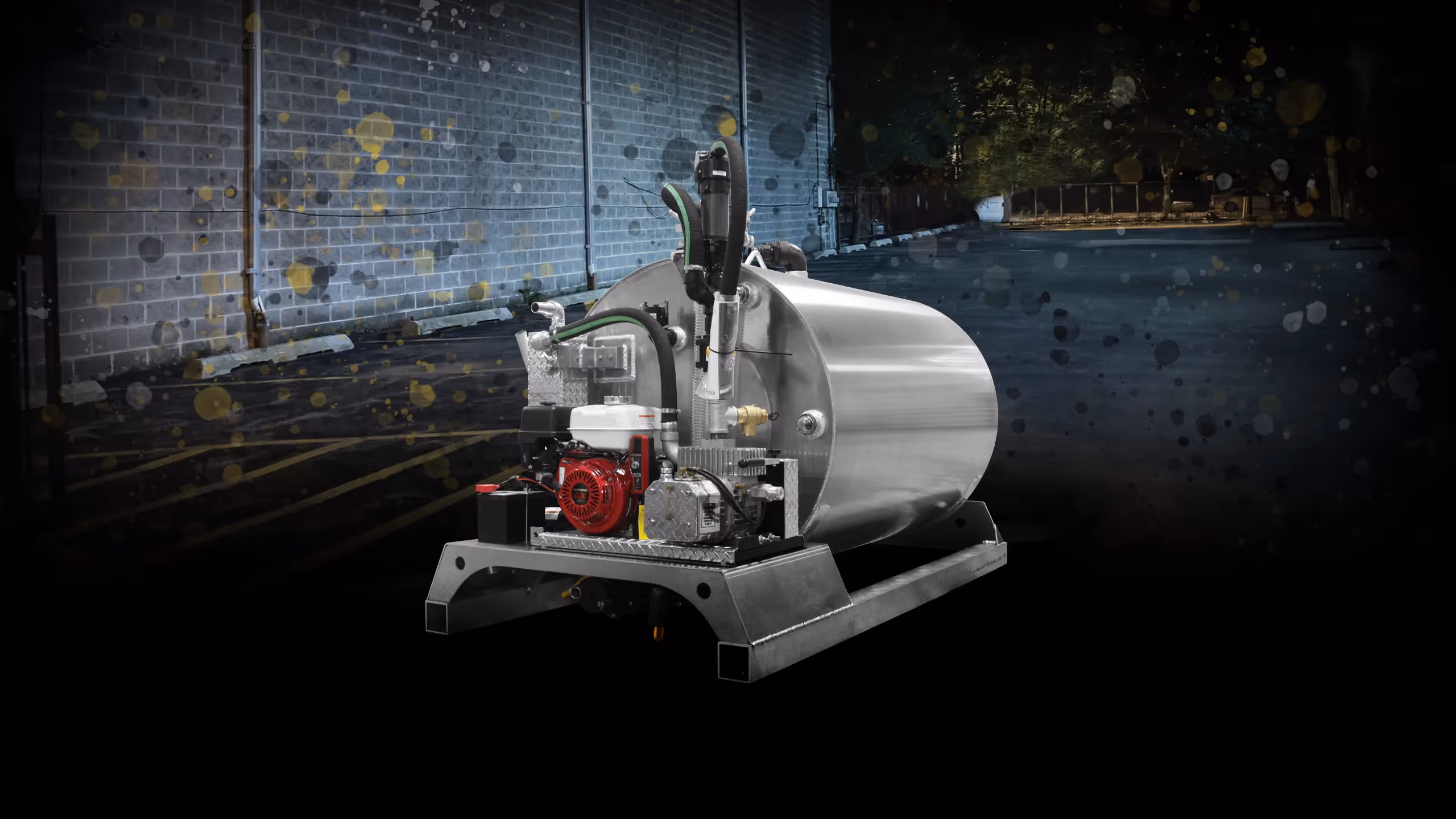 Industrial metal tank with attached engine and hoses on a sturdy frame in a dimly lit outdoor setting.