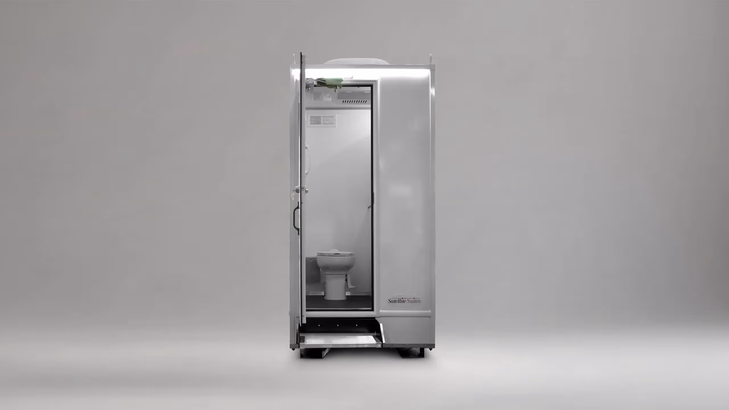 Portable outdoor restroom unit with an open door showing a toilet inside, branded Satellite Suites.
