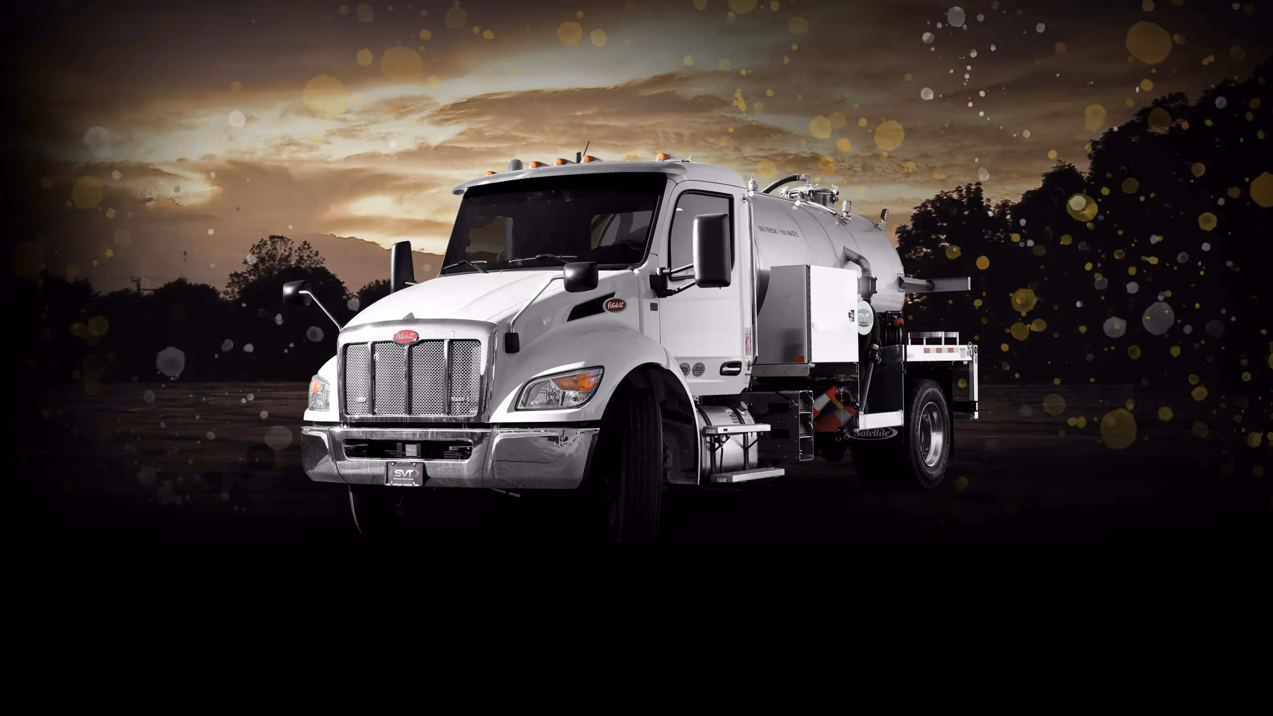White Peterbilt vacuum truck against a dark background with a cloudy sky and abstract splashes.