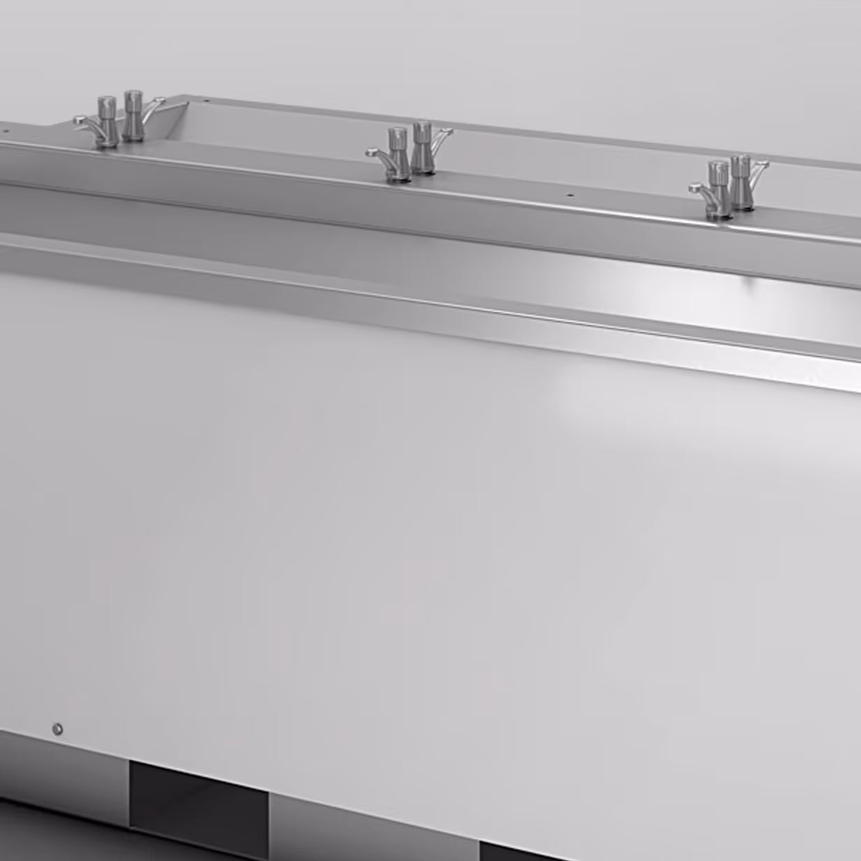 Long stainless steel sink with three sets of faucets and push-button handles on top.