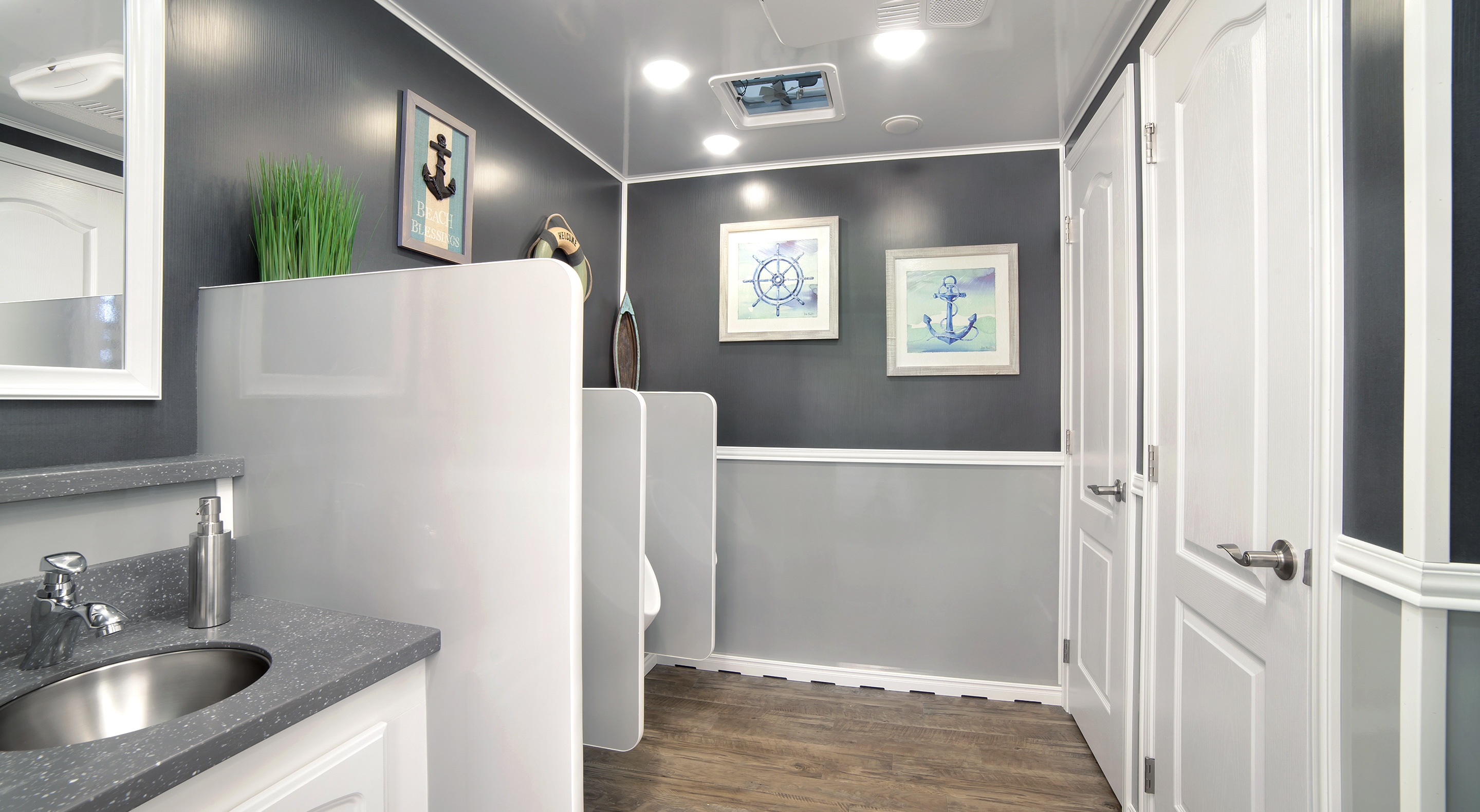 Modern spa bathroom featuring gray walls, a sink, and decorative nautical artwork.