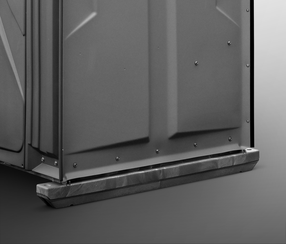 Close-up of the base and lower side panels of a portable restroom unit.