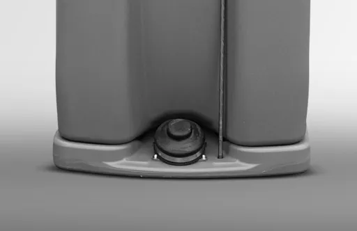 Close-up of a gray plastic container base with a round black valve and a vertical handle.